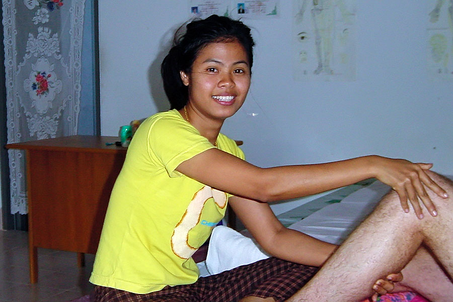 Young masseuse in a Thai massage shop working on my legs