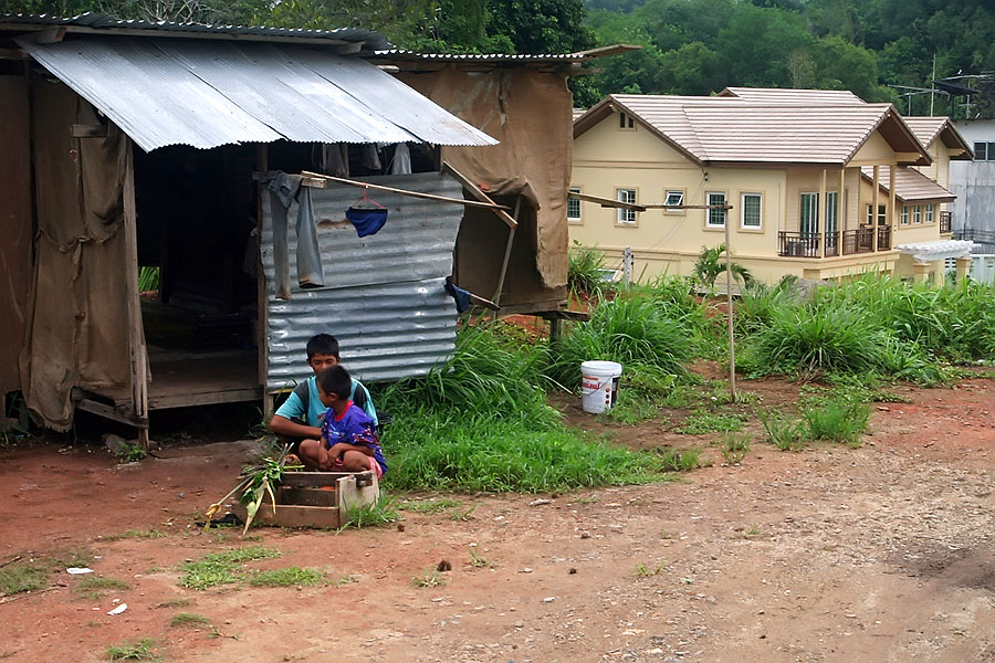Construction workers' corrugated shack in the foreground and large private house in the background