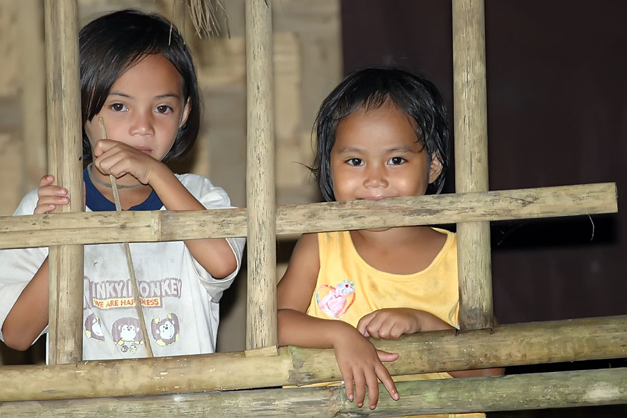 Two young Mon girls living in a house on the banks of the river