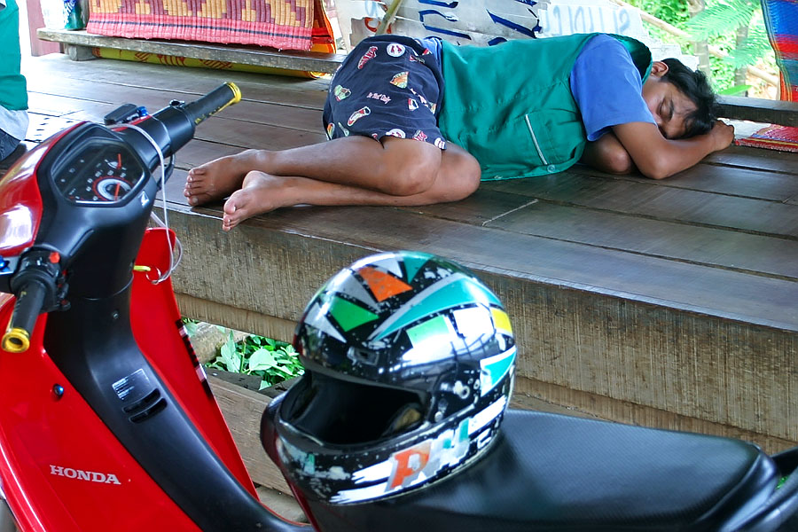 A motorcyle taxi driver doing what Thais do best