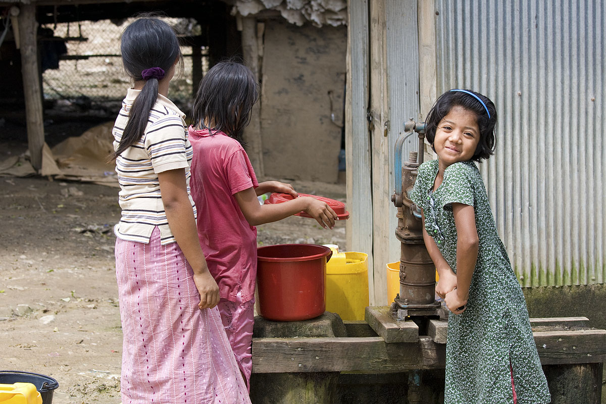 A young Burmese girl pumps water in Mae Sot