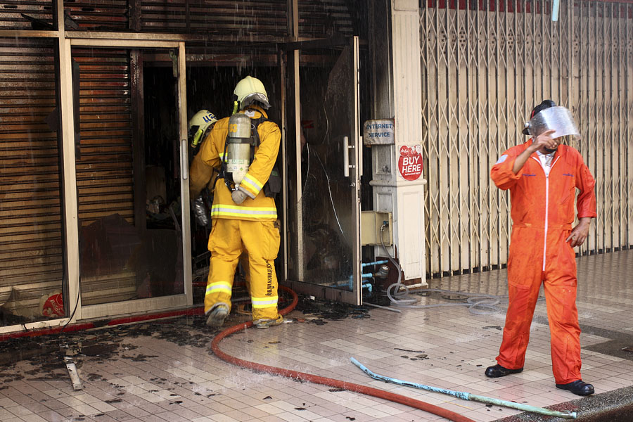 Firefighters with breathing apparatus checking for people inside, Hat Yai, Thailand