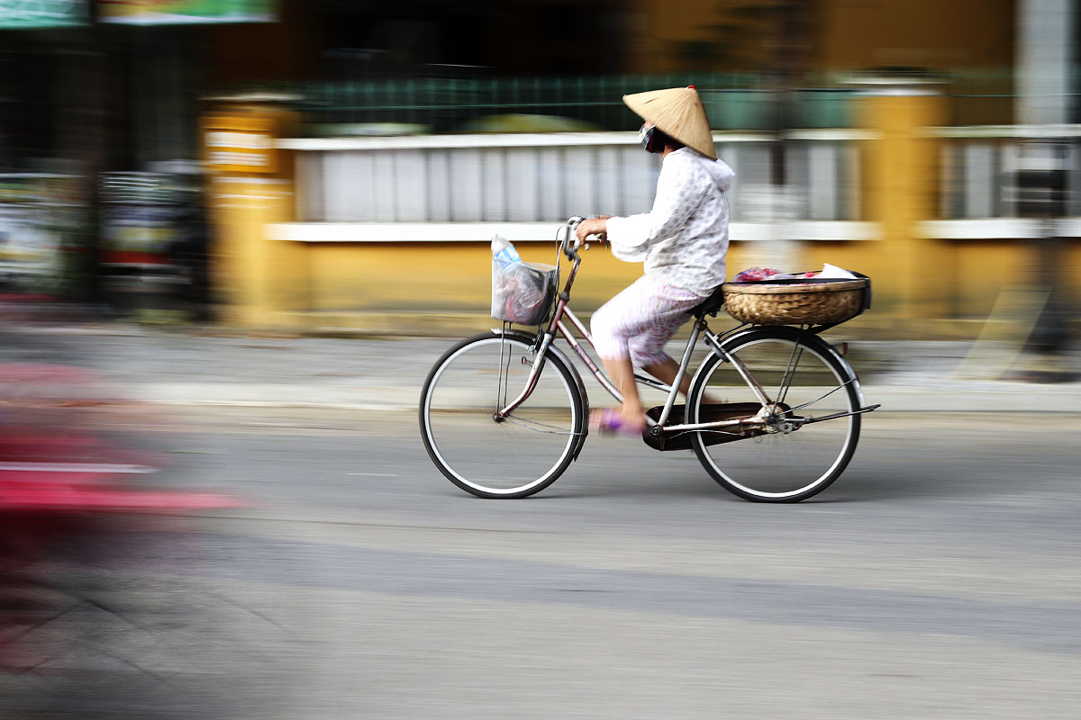 Woman cycling, Hoi An, Vietnam